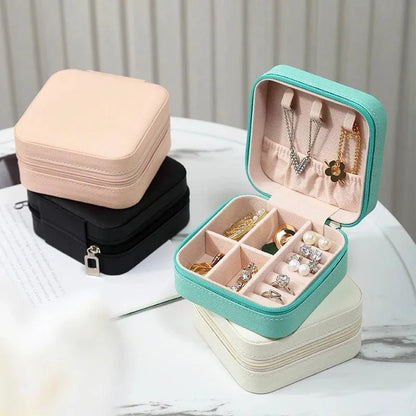 Portable mini jewelry storage box with compartments for rings, earrings, and necklaces.